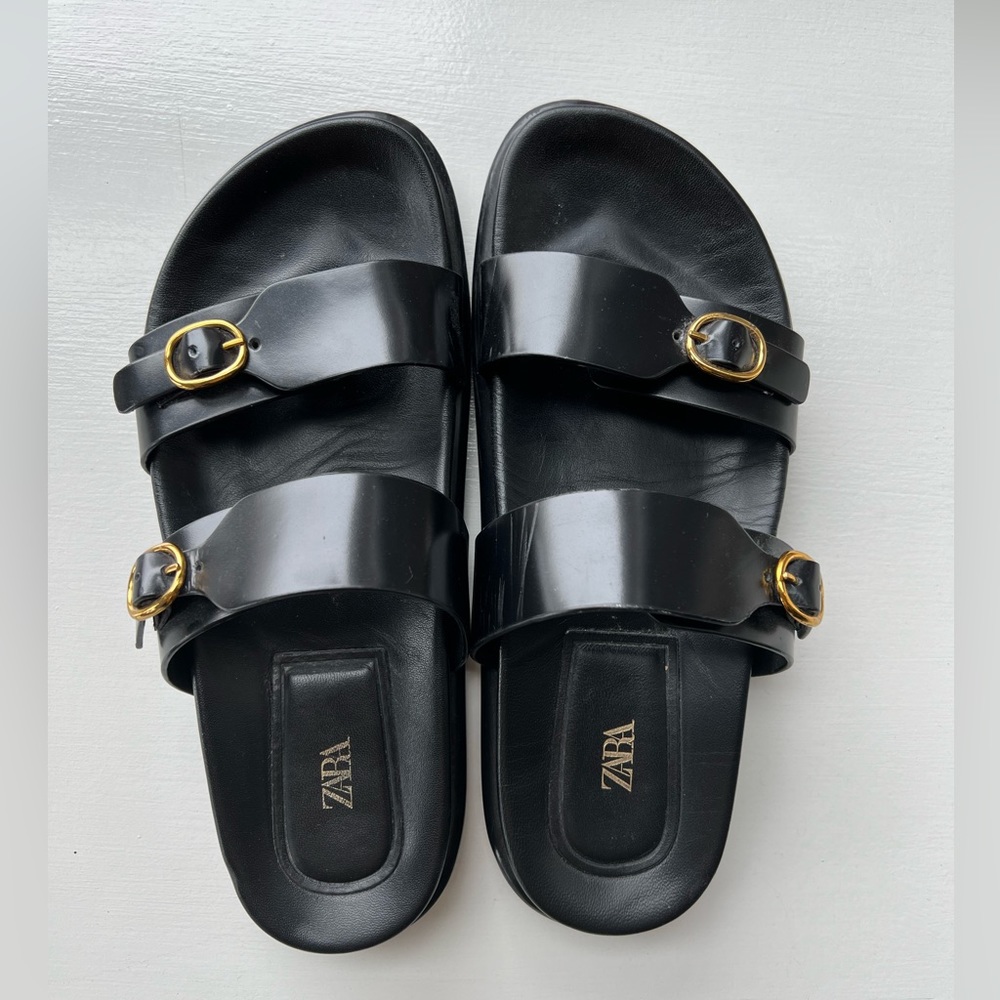 Black leather sandals with gold buckles